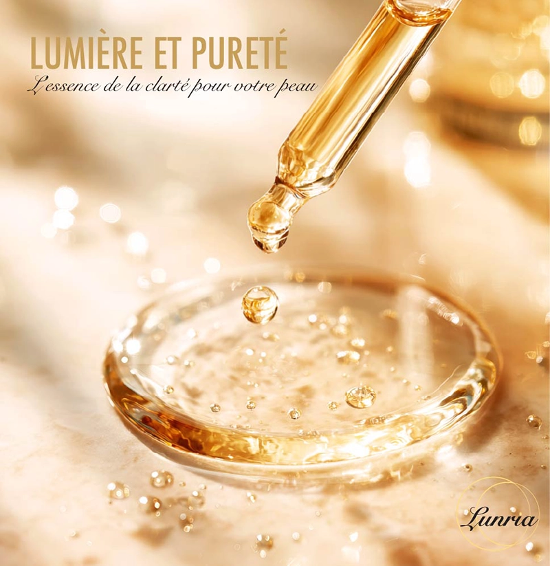 L'image montre des gouttes individuelles d'essence de Lunria scintillant d'une teinte dorée à la surface de l'eau.